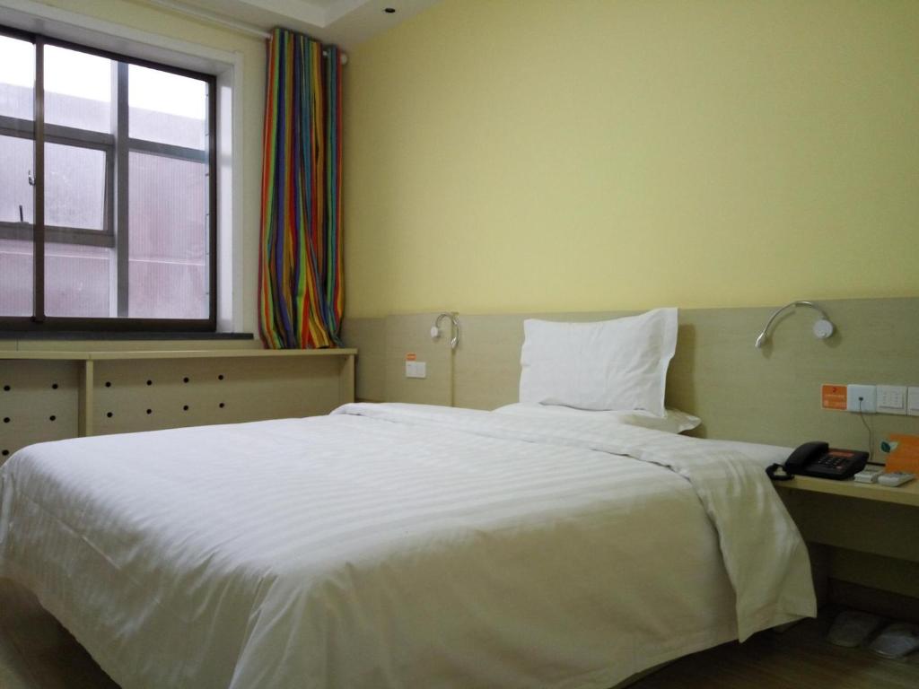 榆林7天酒店·榆林广济大厦店的卧室设有一张白色大床和一扇窗户。