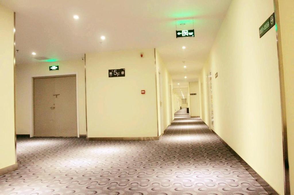 渭南7天酒店·渭南解放路火车站店的空的走廊,有白色的门,铺有瓷砖地板