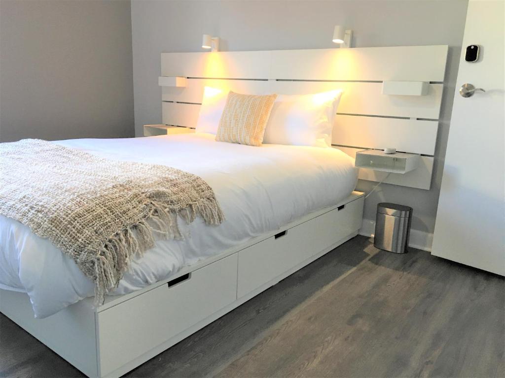 渥太华Simply Stays的卧室配有白色的床头板和白色的床