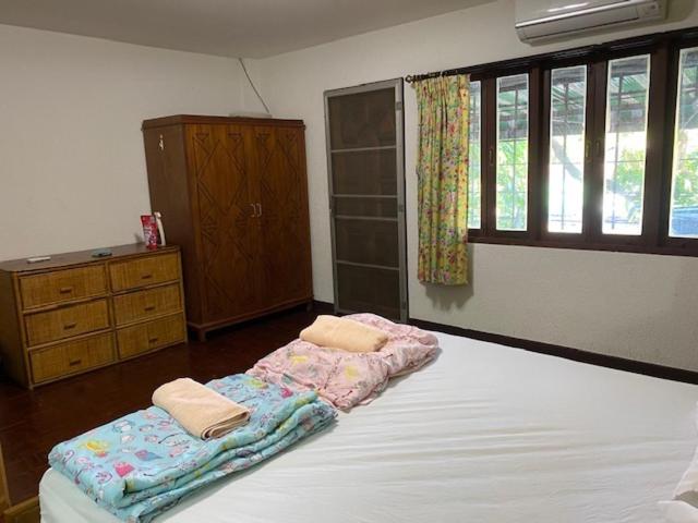 查汶迪卡查亚旅舍的一间卧室配有一张床,上面有两条毛巾