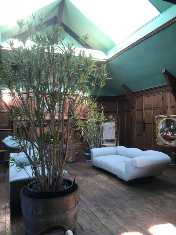吉维尼L'Atelier du Paysagiste - maison d'artiste的客厅配有白色沙发和植物