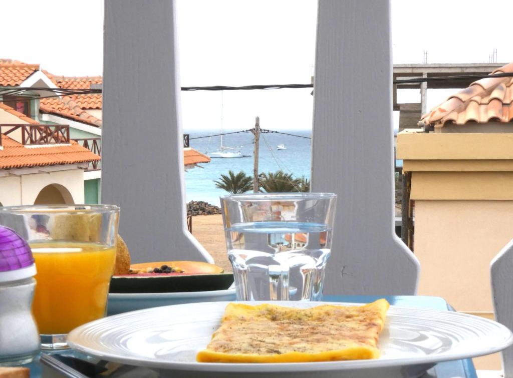 圣玛丽亚Hotel MiraBela的一块带烤面包和一杯橙汁的盘子