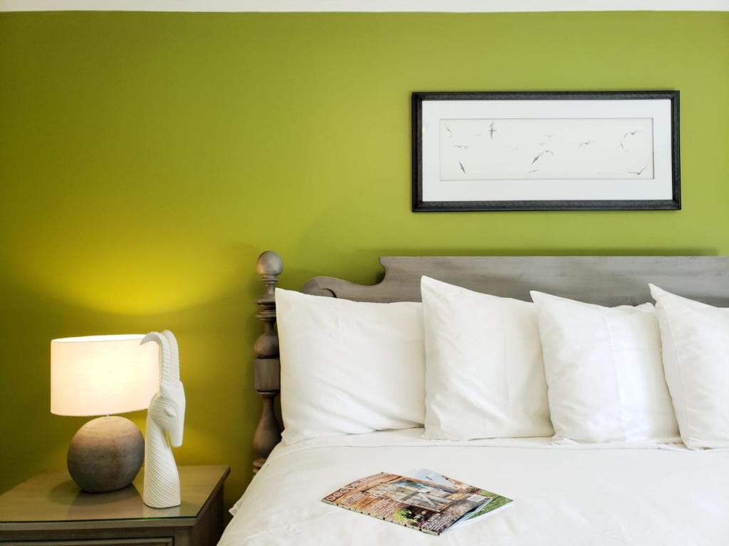 巴港The Primrose的一间卧室设有绿色的墙壁和一张带白色枕头的床。