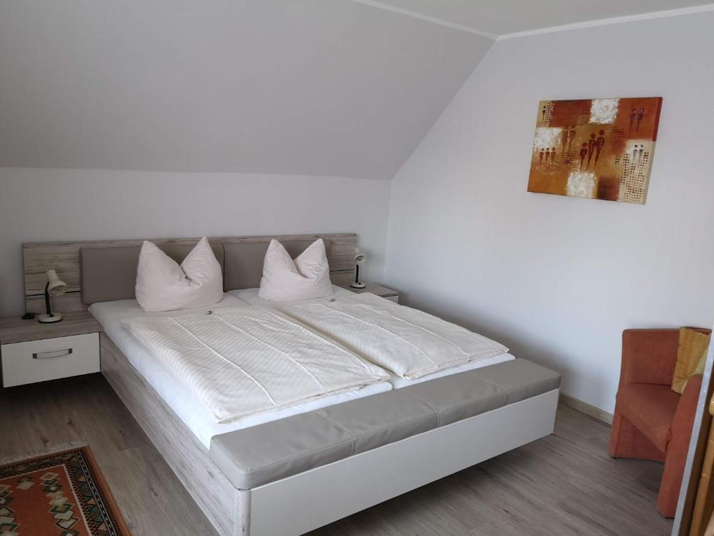 旺格兰Pension Arndt UG的一间卧室配有带白色床单和枕头的床。