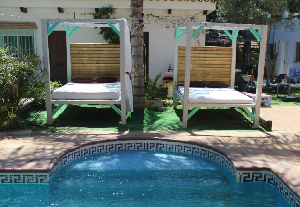 奇克拉纳－德拉弗龙特拉Casa Rural Los Pepe Sancti Petri的一座带两把椅子和一张床的游泳池
