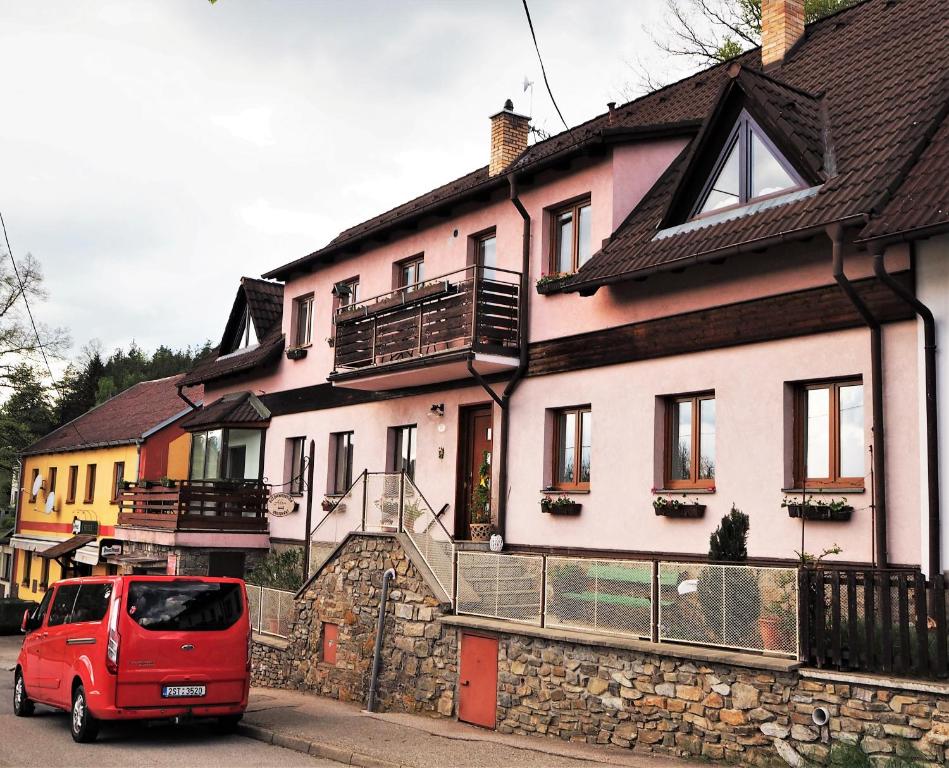 捷克克鲁姆洛夫亚当公寓式酒店的停在房子前面的一辆红色面包车