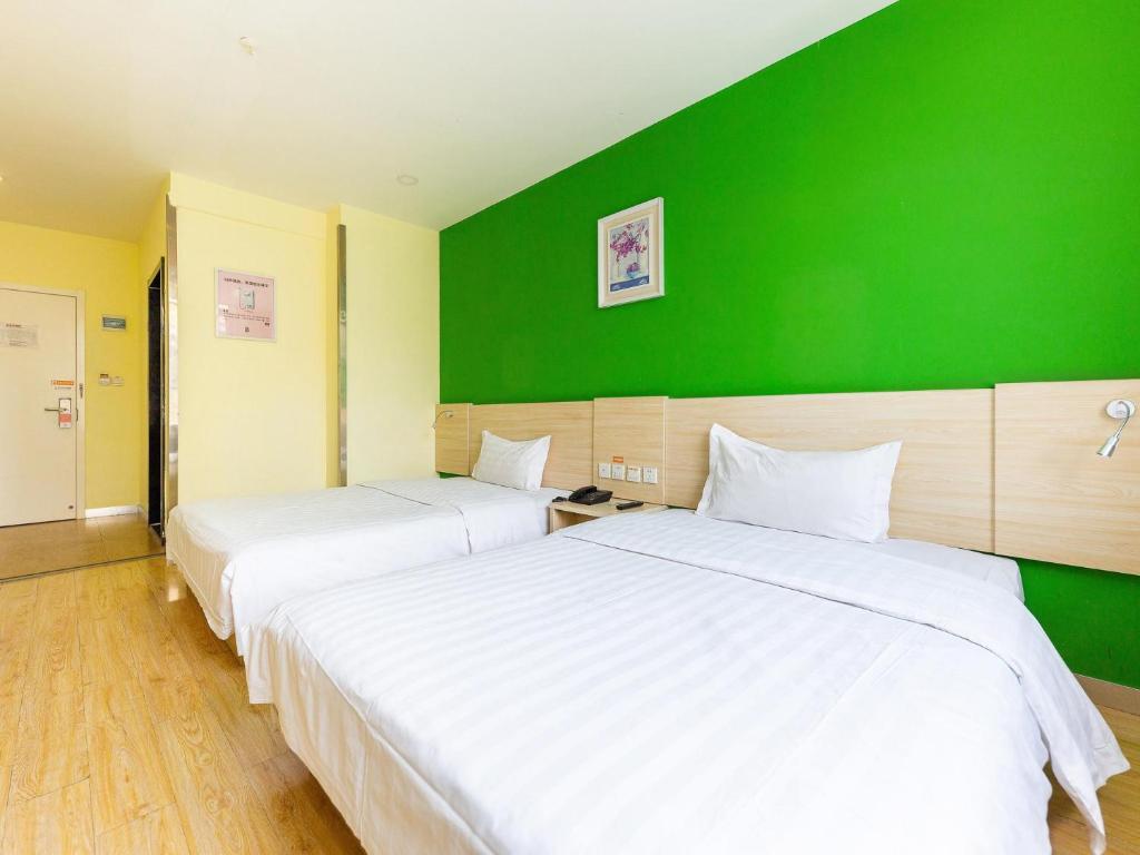 西宁7天酒店·西宁昆仑路十字店的绿墙客房的两张床