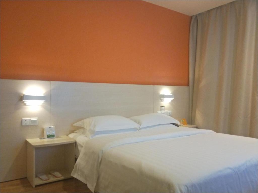 乐山7天酒店·峨眉山中心店的一间卧室配有一张大床和两个枕头