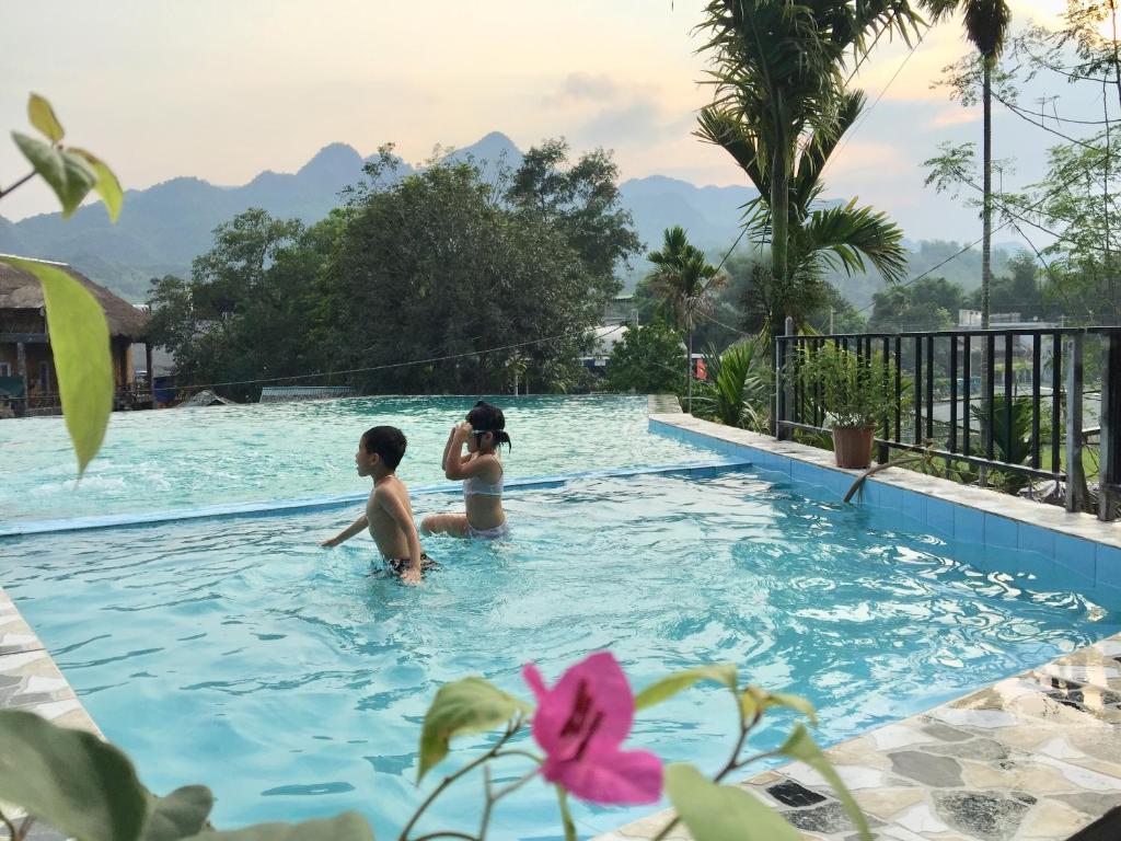 枚州县枚州日落精品酒店的两人在度假村的游泳池游泳