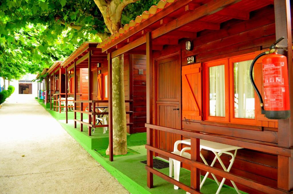 波多诺伏Camping Playa Canelas的一排配有桌椅的小木屋