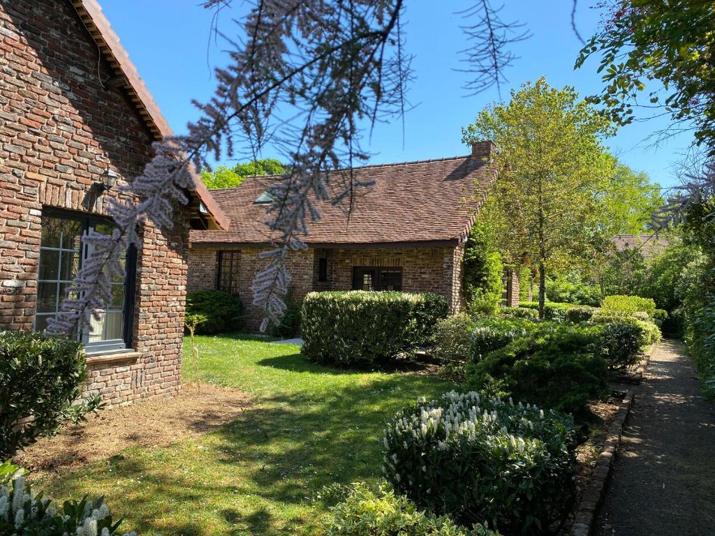 梅斯尼圣佩尔Les Cottages d'Orient Premium的砖屋,有灌木的院子