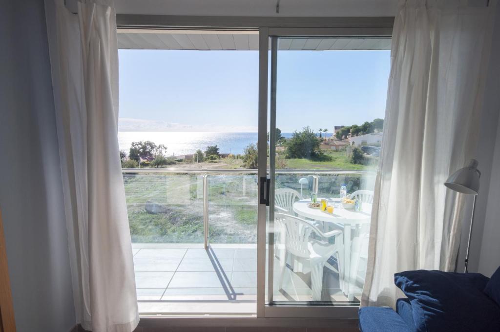 卡尔佩Homeincalpe Borumbot的客房设有滑动玻璃门,享有海景。