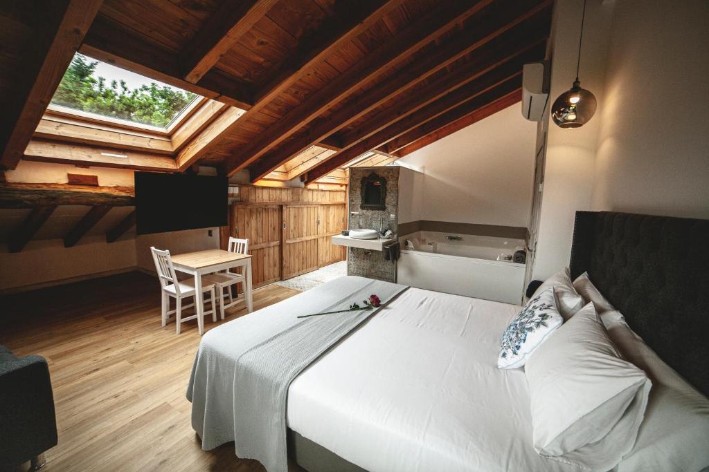 PámanesPosada La Corralada的卧室配有一张白色的大床和一张桌子