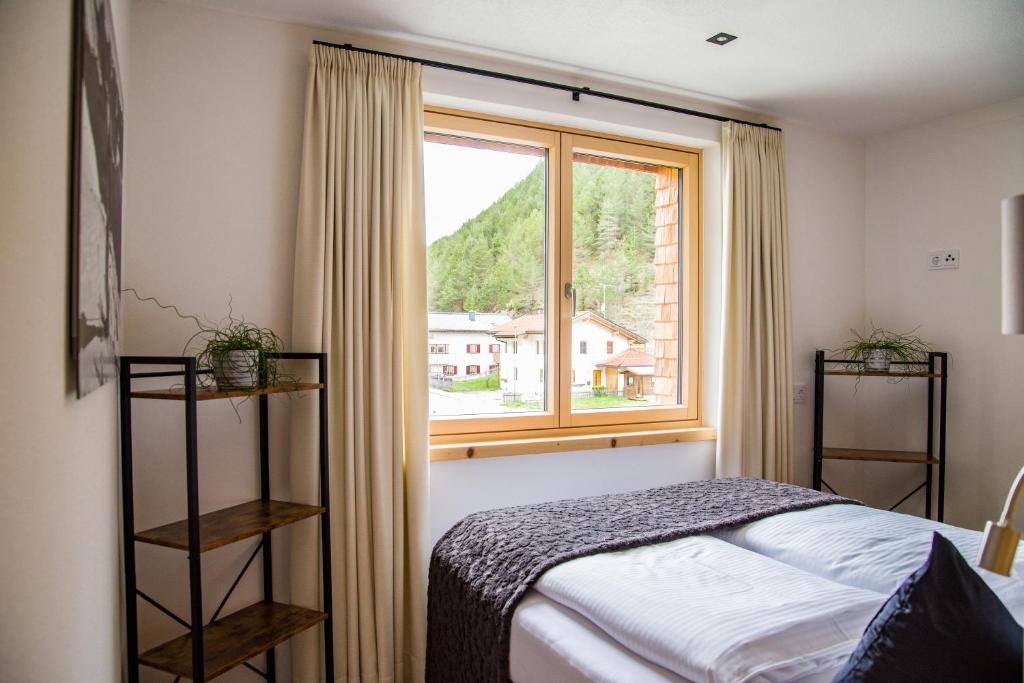 施特格Fetz Luxury Appartements的一间卧室设有一张床和一个窗口