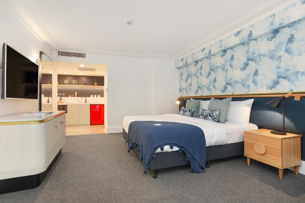 悉尼Coogee Bay Boutique Hotel的一间卧室配有一张蓝色和白色墙壁的床