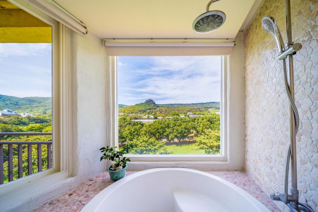 垦丁大街萌香渡假旅店的带浴缸的浴室和窗户