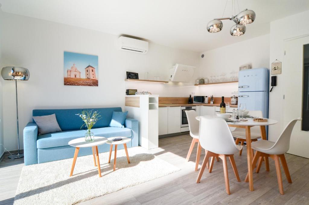 米库洛夫Apartmán Astrid的客厅配有蓝色的沙发、桌子和椅子