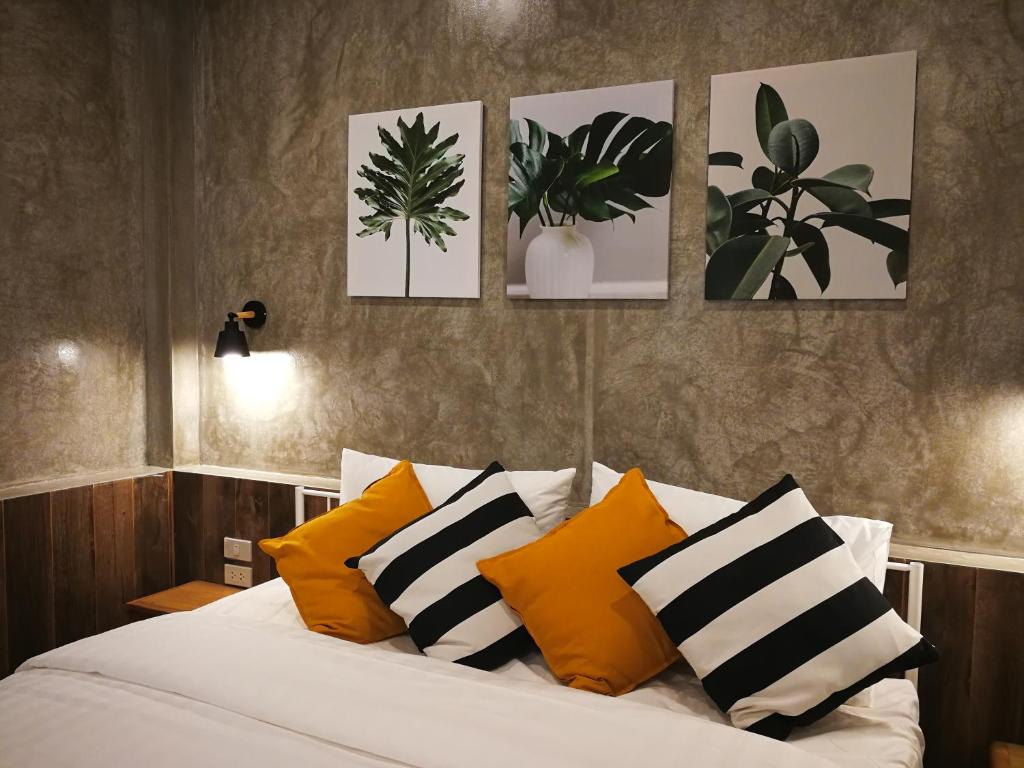 Bangkok Noibaankorrakang的卧室配有一张四幅画的墙壁床。