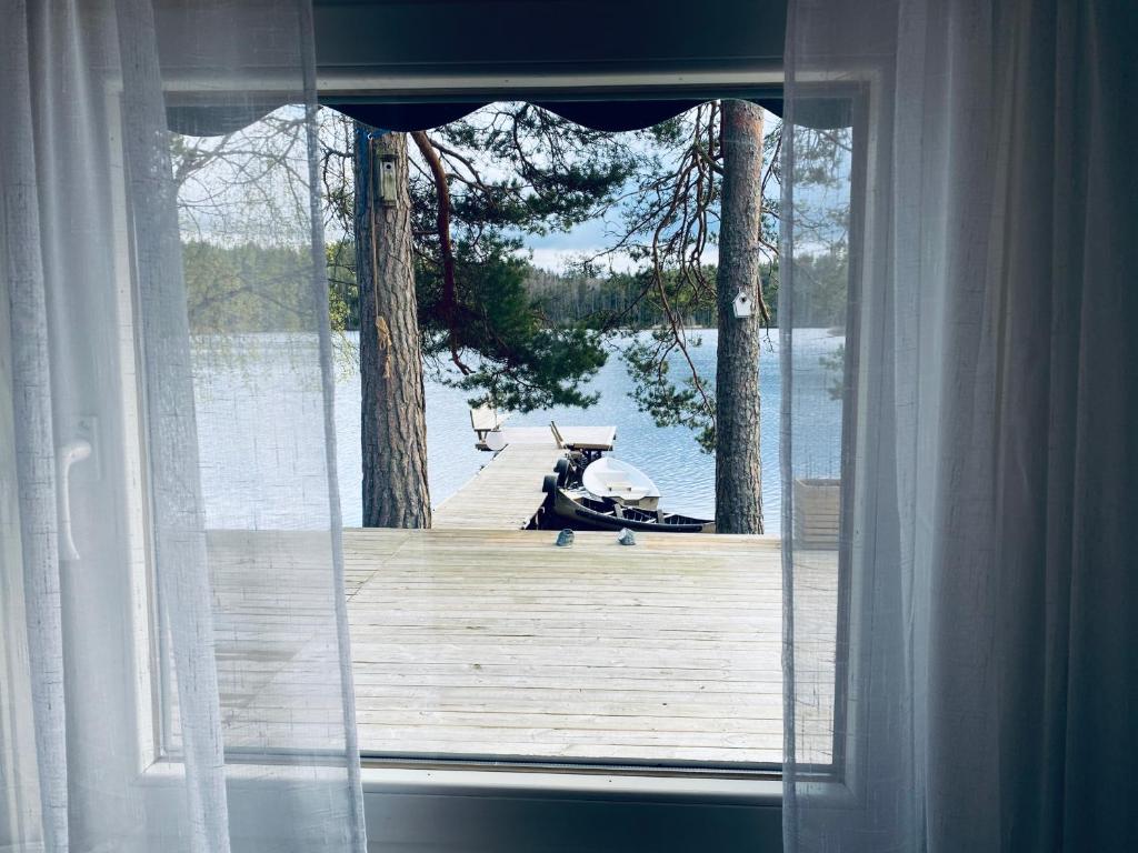 韦特兰达Stuga Holmasjön的享有木码头景致的窗户