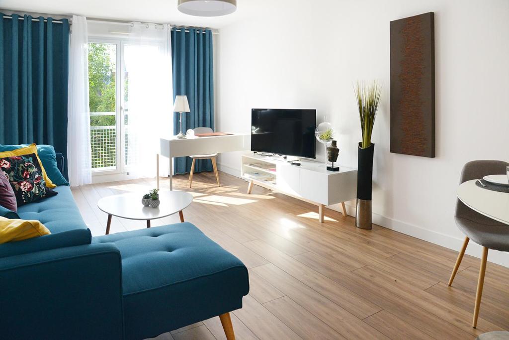 图尔昆Business Appart的客厅配有蓝色的沙发和电视