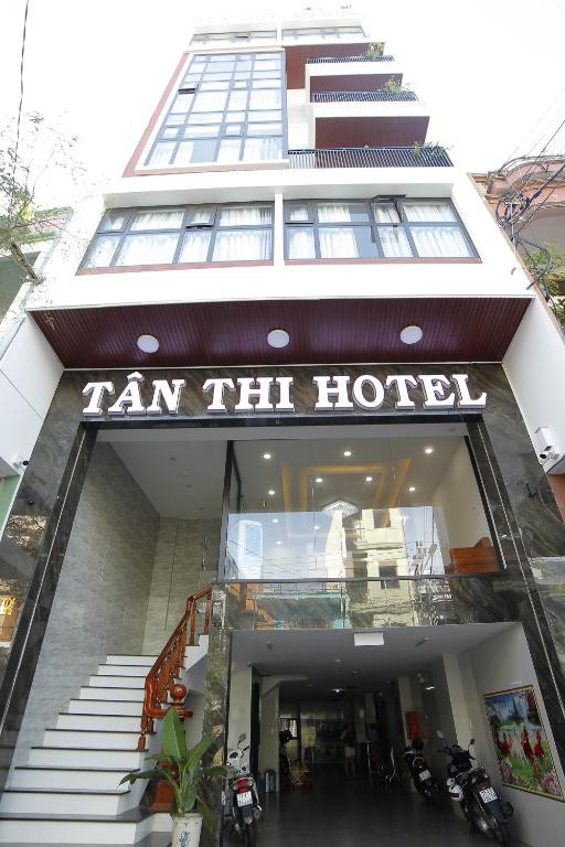 归仁Tân Thi Hotel的一座带有阅读塔姆酒店标志的建筑