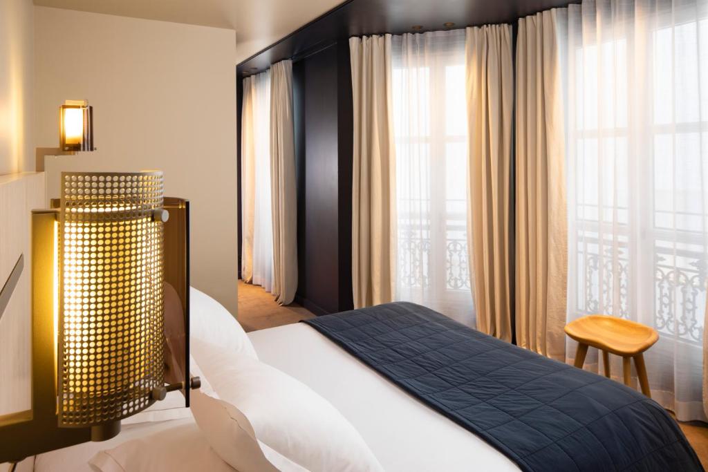巴黎德内尔酒店的一间卧室设有一张床和一个大窗户