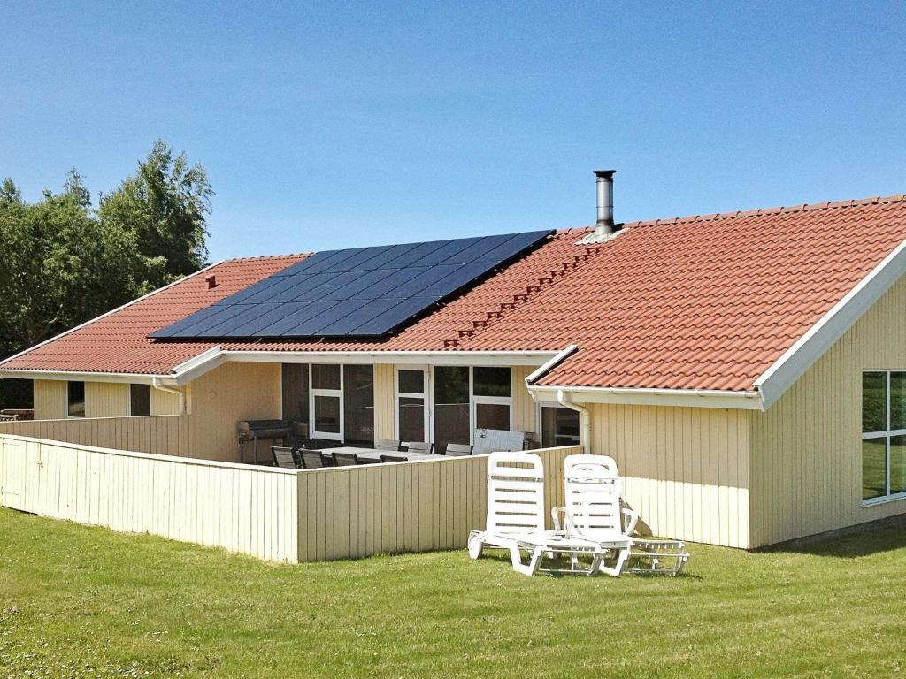 诺德堡12 person holiday home in Nordborg的屋顶上设有太阳能电池板的房子