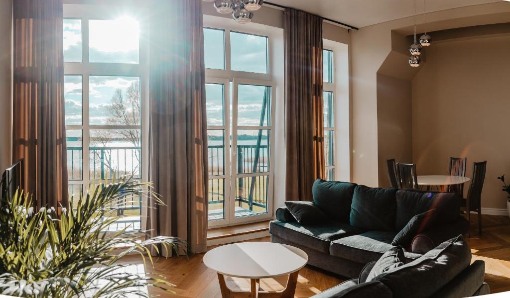 沃鲁Tamula Sunset Apartment的带沙发和大窗户的客厅
