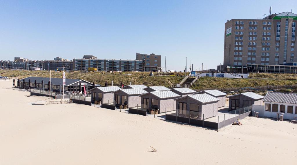 赞德沃特STRAND 21 hotelchalets的沙滩上的一排沙滩小屋