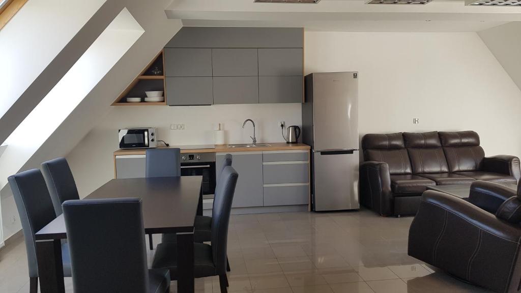 姆拉哥沃Apartamenty Mazury Kamienica Centrum的厨房以及带桌椅的起居室。