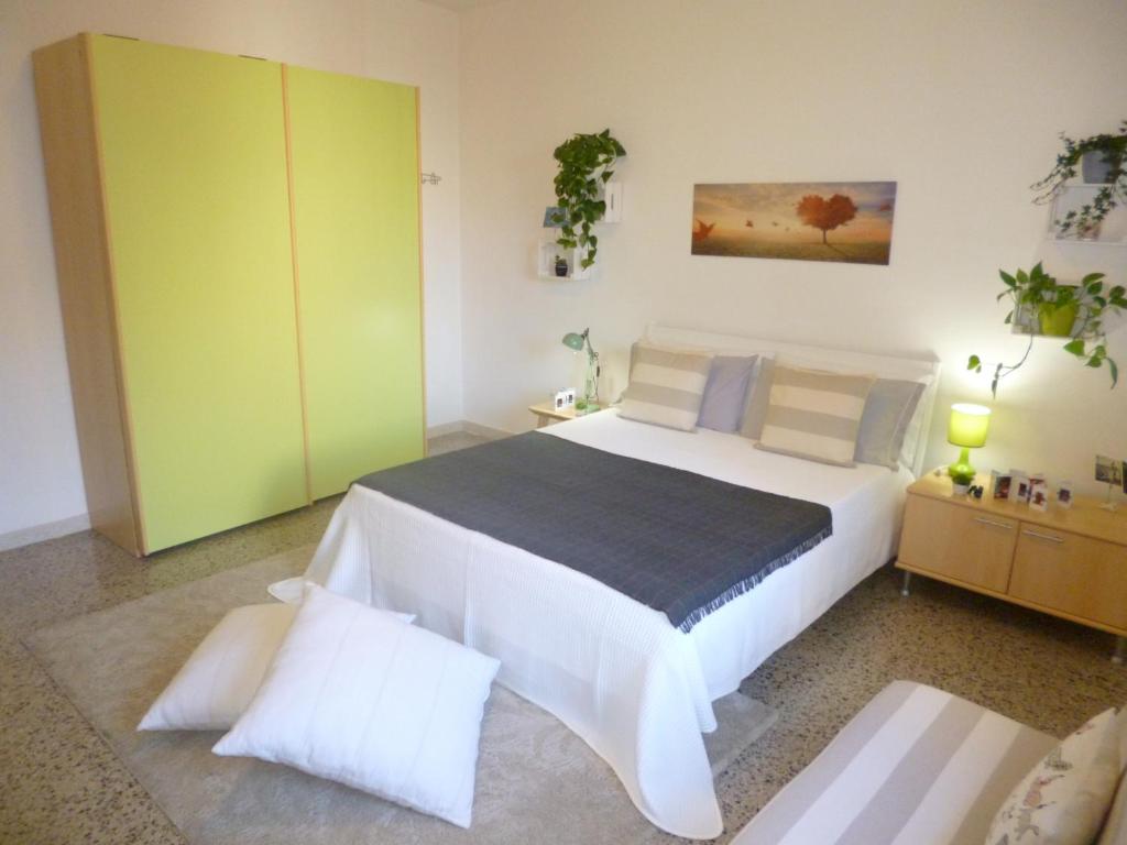 卡利亚里EcoBoutique house, self check-in - free car parking的卧室配有一张白色大床和绿色橱柜。