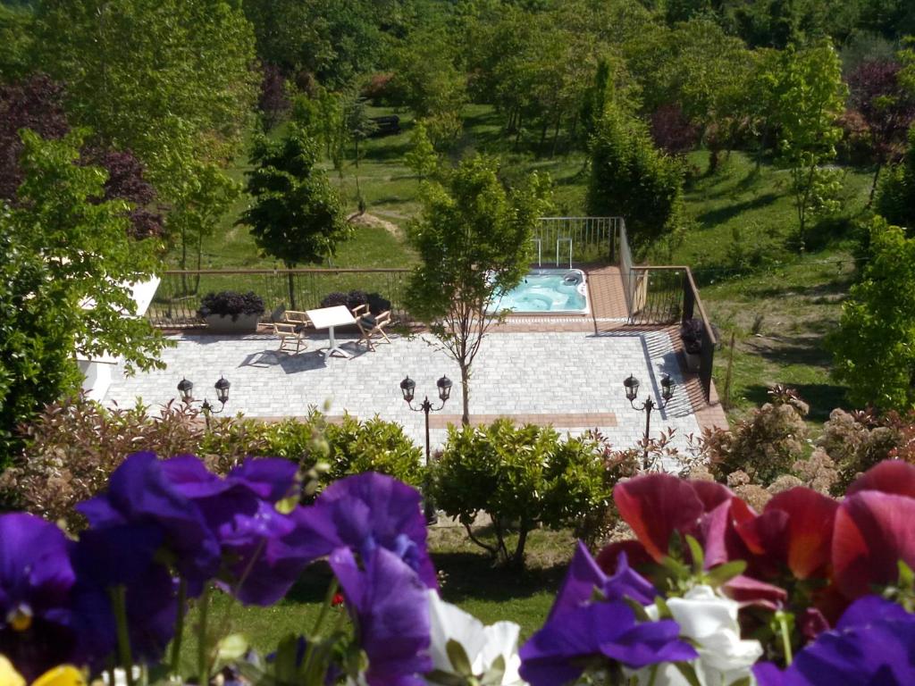 乌尔比诺Albergo Diffuso - Il Poggetto tra Urbino & San Marino的一个带游泳池和鲜花的花园