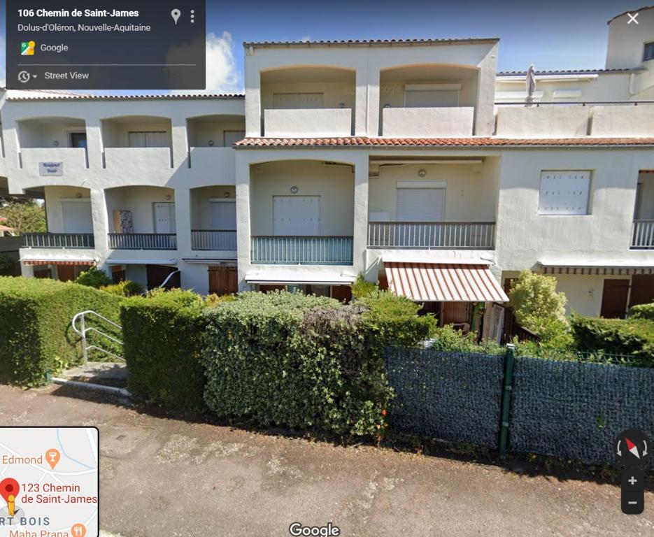 Grand-Village-PlageAppt Dolus-d'Oléron, Vert bois 2-3 personnes的前面有栅栏的建筑