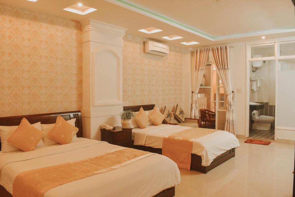 顺化Hue Harmony Hotel的酒店客房带两张床和一间浴室