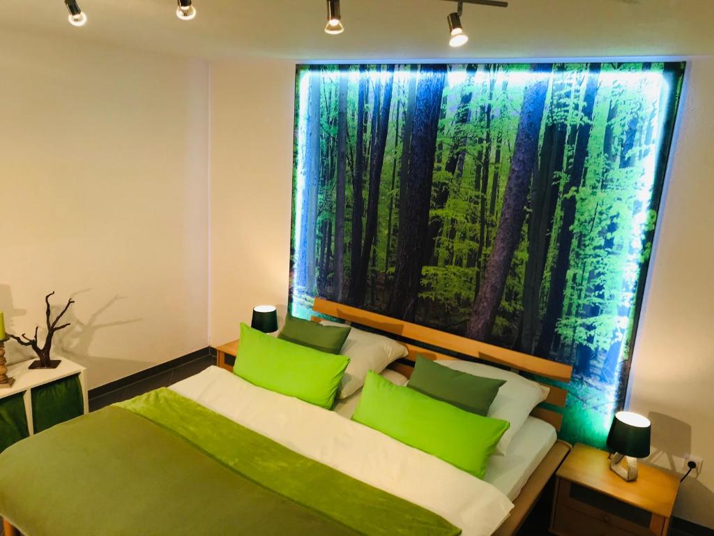 RainauLimes Apartment -übernachten am Limes-的一间卧室配有一张带绿色枕头的床和一扇窗户