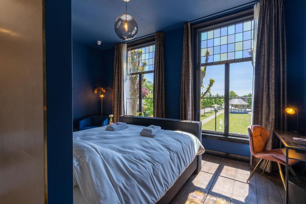 RiethovenBoutique hotel Lytel Blue的一间蓝色卧室,配有床和2个窗户