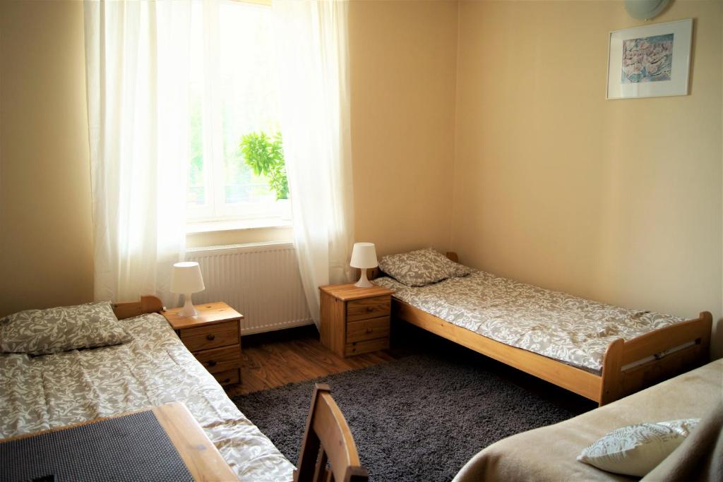 卢布林Willa Ostoja的一间卧室设有两张床、一个窗口和一张桌子