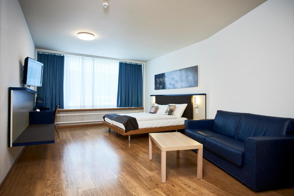 苏黎世苏黎世布里斯托尔酒店的酒店客房配有床、沙发和电视。