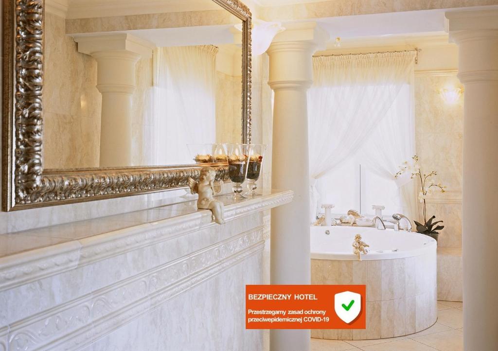 弗沃茨瓦韦克亚历山大酒店的一间带大镜子和浴缸的浴室