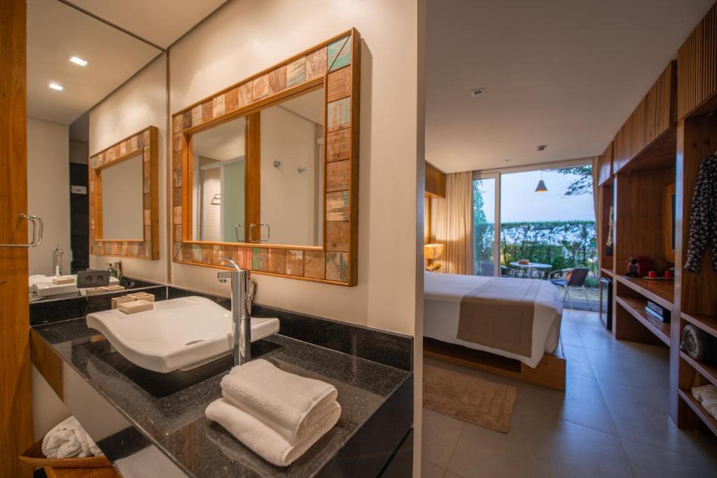 坎布里Hotel Spa Nau Royal的一间带水槽的浴室和一间带一张床的卧室