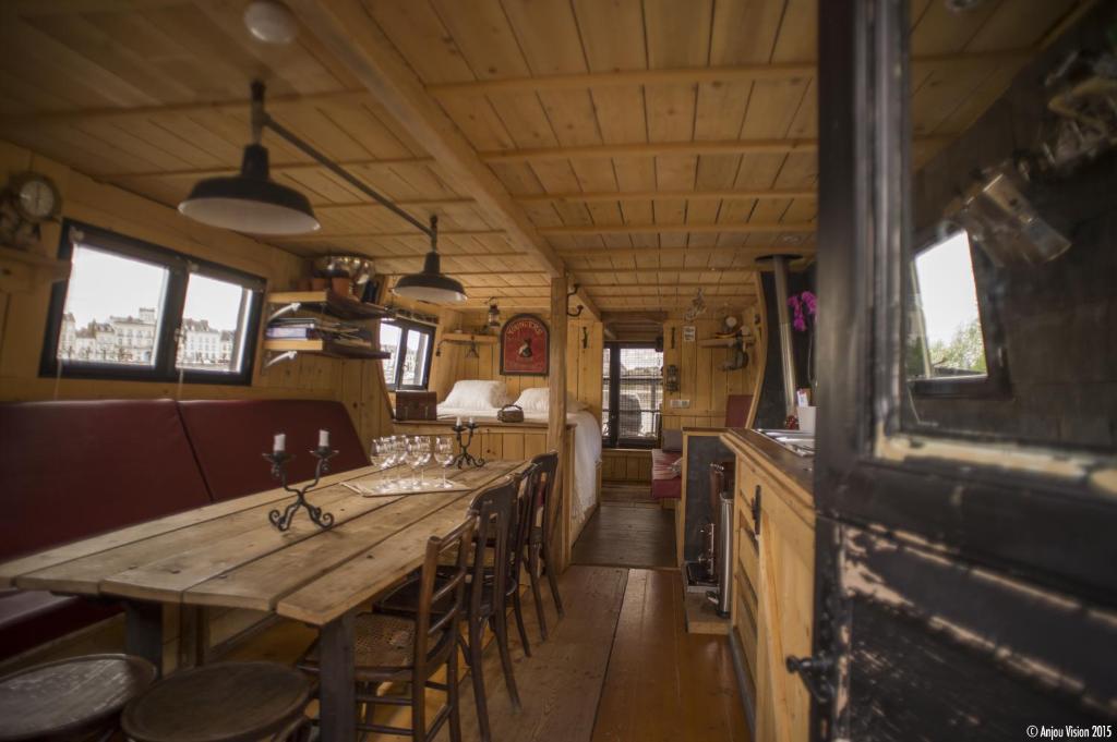 索米尔BATEAU LE VENT DE TRAVERS的一间带木桌和椅子的用餐室