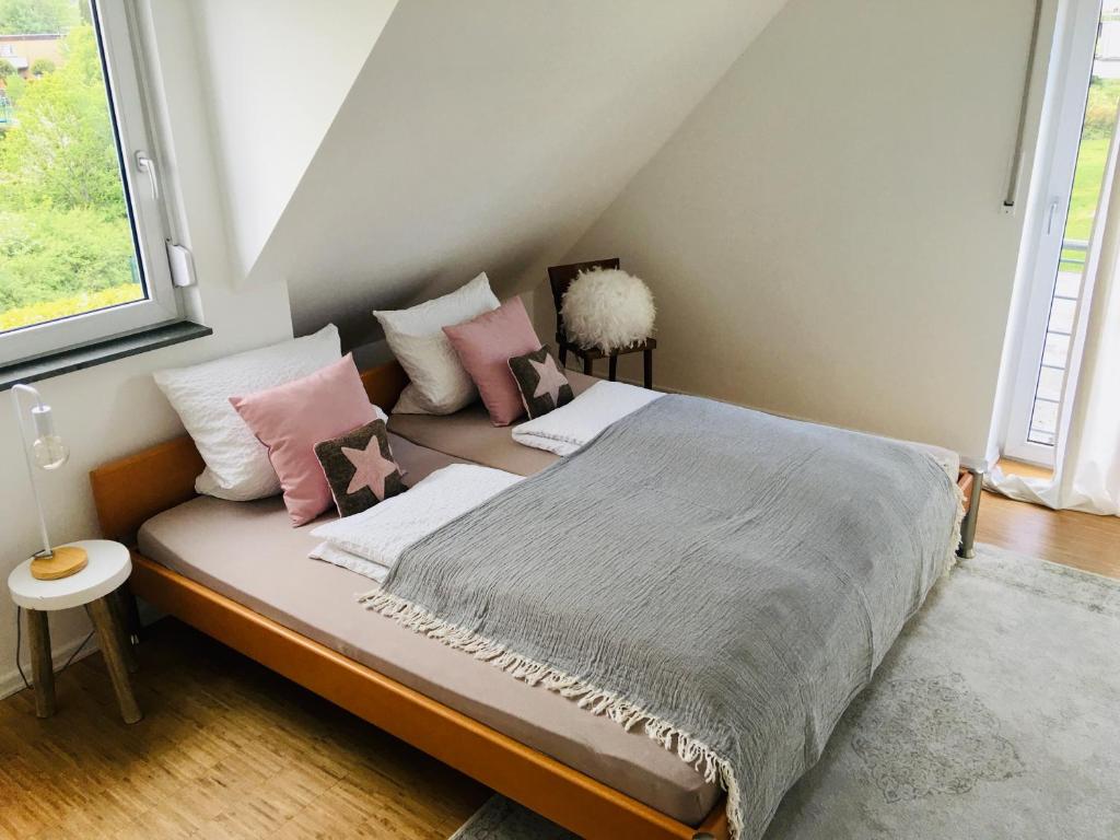 默讷塞Apartment Urlaubsrausch am Möhnesee的一间卧室配有带粉色和白色枕头的床
