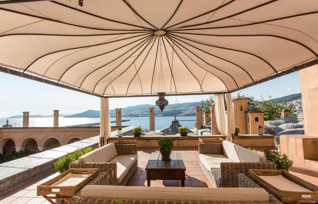 卡瓦拉伊马雷特酒店的露台上的大遮阳伞,配有椅子和桌子