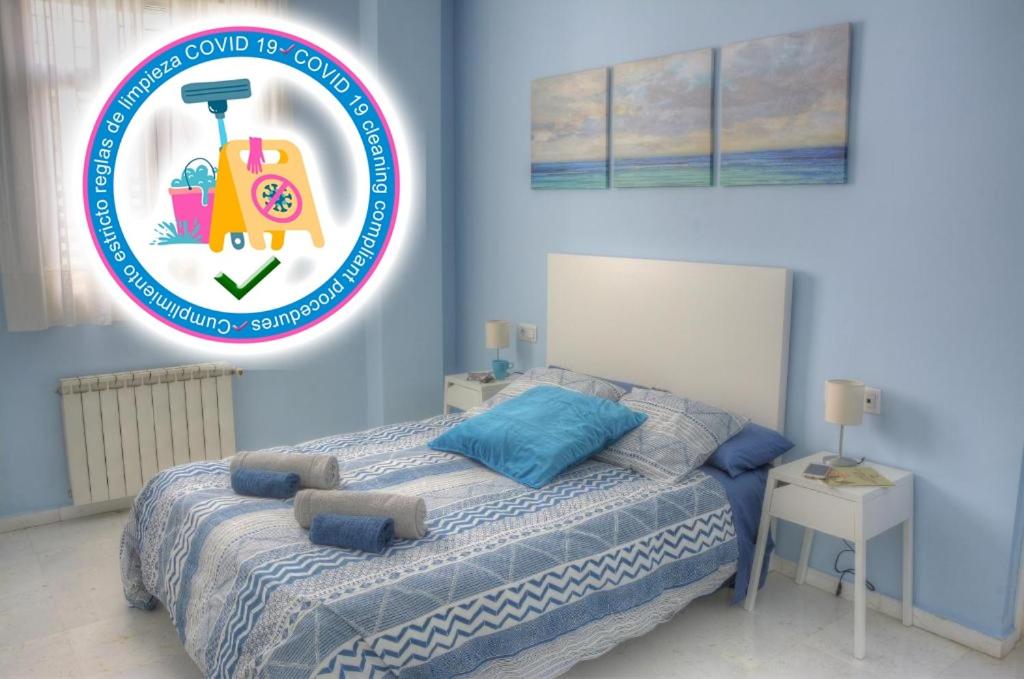 塞维利亚SEVILLA BUTTERFLY SUITES的蓝色卧室,配有一张上面标有标志的床