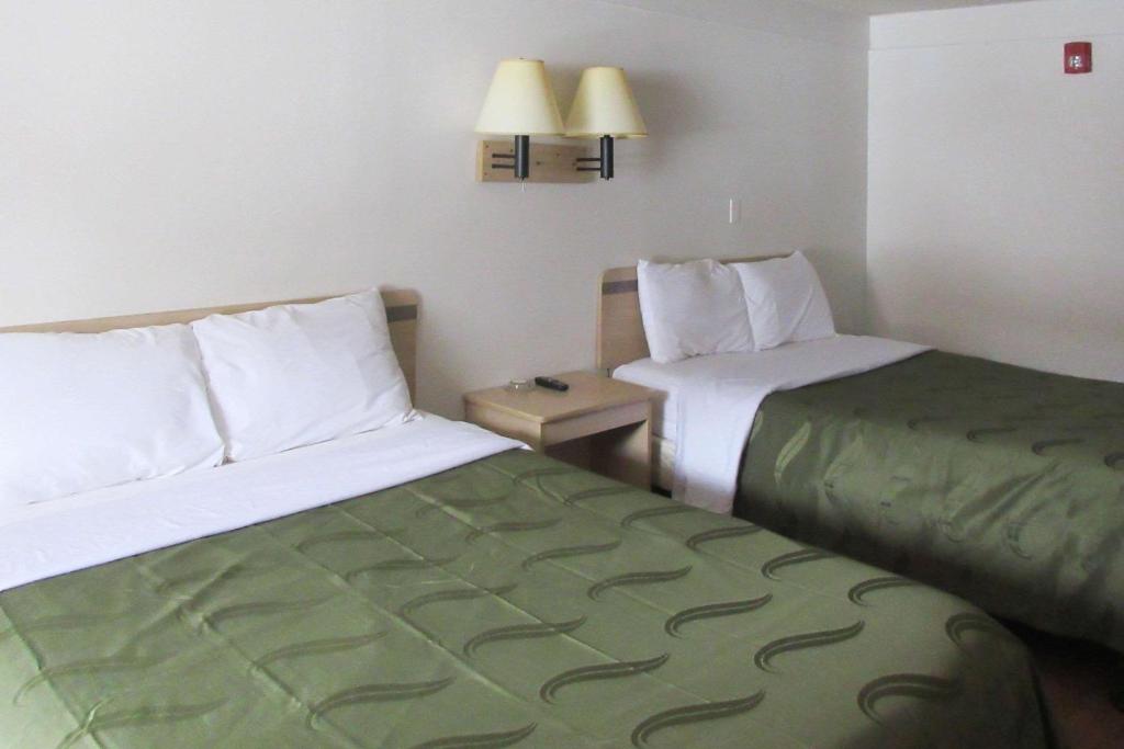 华盛顿Rodeway Inn的酒店客房设有两张床和一张桌子。