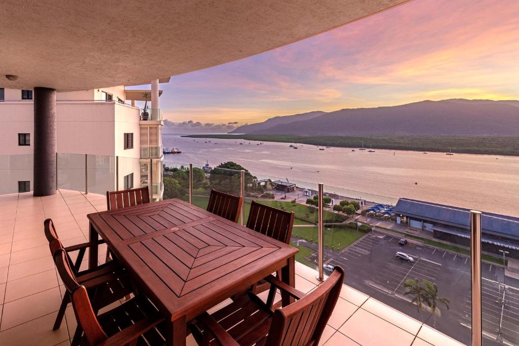 凯恩斯凯恩斯皮尔蒙德公寓酒店的阳台配有桌椅,享有水景。