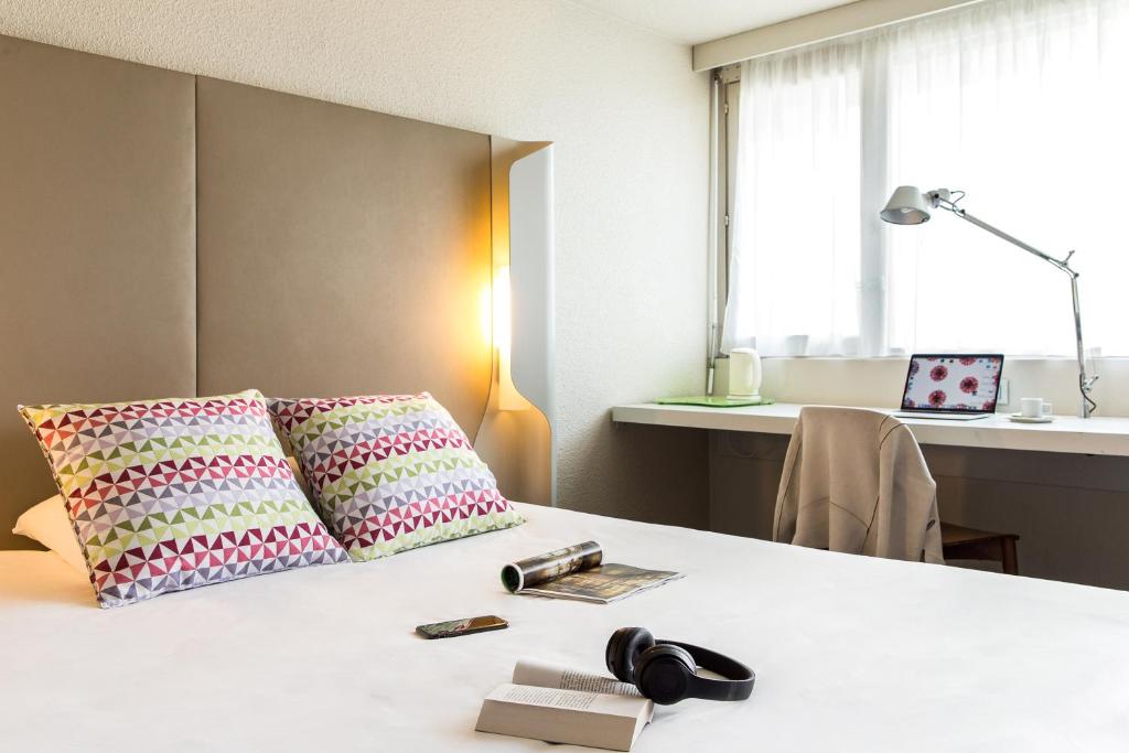 盖雷钟楼杰雷酒店的客房配有带2个枕头的床和书桌。