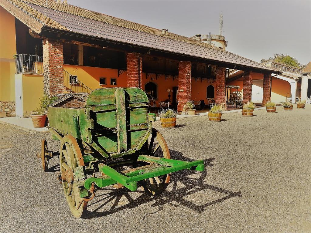 PasturanaCountry House Cascina Orto的旧的绿色车,坐在大楼前