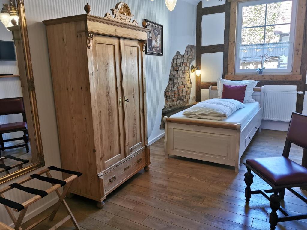 艾森贝格摩根喷泉酒店的一间卧室配有一张床和一个大型木制橱柜