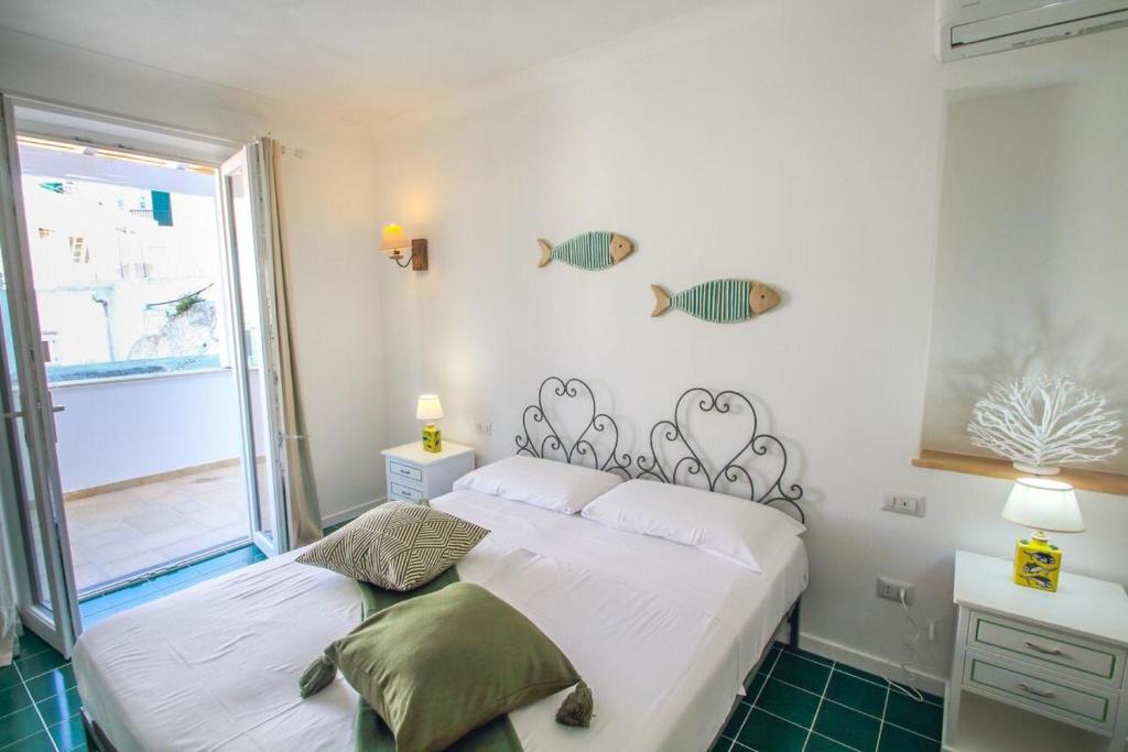 蓬扎Casa Pesce的一间卧室设有一张床,墙上设有一扇窗户,窗户上放着鱼